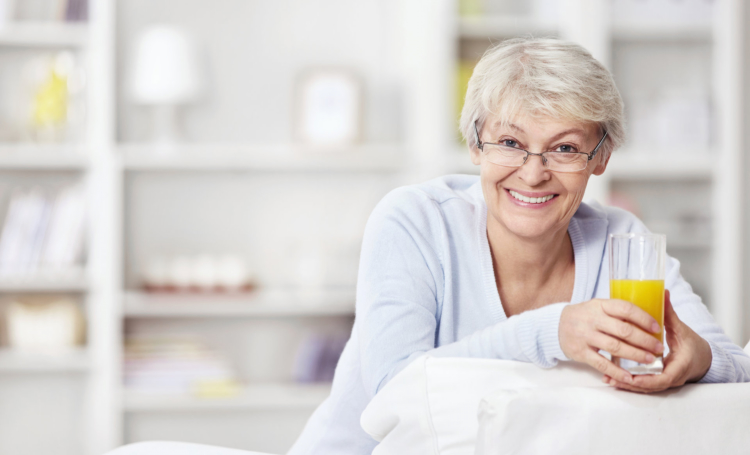 Female senior holding a glass of juice