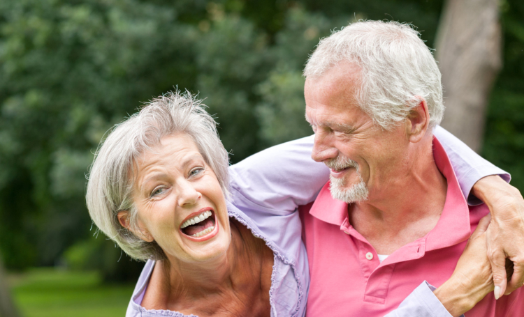 Female senior laughing and her husband is watching her